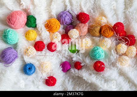 Un sacco di filo colorato a maglia in forma di palle giacciono su soffice coperta. Foto Stock