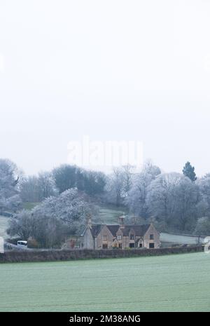 Case semi-disintagliate fatte di pietra calcarea di magnesio locale, adagiate nella campagna del Derbyshire e alberi ricoperti di ghiaccio. Foto Stock