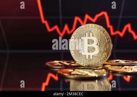 Immagine della crisi finanziaria e della recessione globale nel mercato della criptovaluta e degli investimenti, stack di bitcoin d'oro sullo sfondo con grafico digitale della criptovaluta con linea rossa spessa Foto Stock