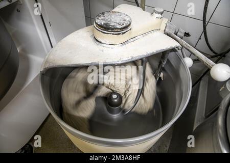 La figura mostra una macchina impastatrice, presso il laboratorio della panetteria 'Bakkerij Bossuyt' di Dilbeek, nella notte da venerdì a sabato, venerdì 27 maggio 2022. A causa della crisi economica in corso a seguito dell'invasione russa in Ucraina, che è succeduta a due anni di blocco del virus Corona, i panettieri si trovano di fronte a un aumento dei costi delle risorse dei prodotti da forno, come la farina di grano, e bollette energetiche elevate. BELGA FOTO HATIM KAGHAT Foto Stock