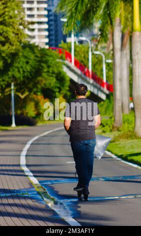 uomo in passeggino lungo il viale di sport e ricreazione Foto Stock