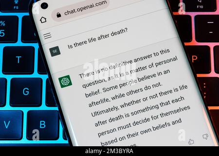OPEN ai ChatGPT chat bot visto su smartphone posizionato sul computer portatile. Ai chatbot ha risposto alla domanda su una vita dopo la morte. Stafford, Regno Unito, Foto Stock