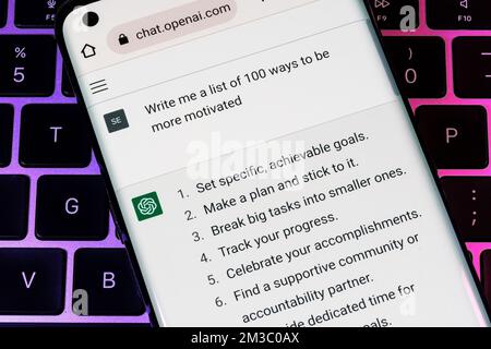 OPEN ai ChatGPT chat bot visto su smartphone posizionato sul computer portatile. Ai chatbot ha risposto alla domanda sulla motivazione. Stafford, Regno Unito, Decembe Foto Stock