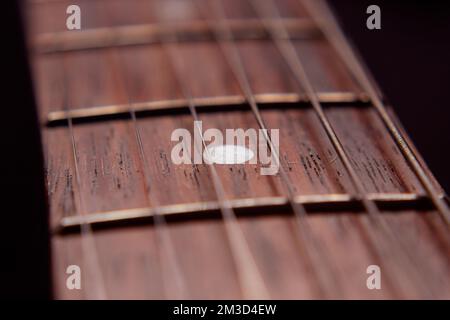 Macro fotografia a sei corde di chitarra elettrica e fretboard in legno. Strumenti vintage e concetto musicale Foto Stock