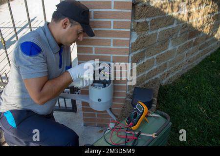 Cablaggio elettrico e riparazione del motore di un cancello automatico in un vialetto di guida. Foto Stock