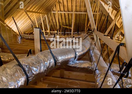 In casa di nuova costruzione sotto costruzione tubi di ventilazione sono in argento materiale isolante sul soffitto della soffitta Foto Stock