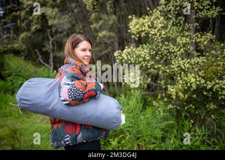 gril andando campeggio con una tenda nel cespuglio. donne escursionismo e campeggio in australia Foto Stock