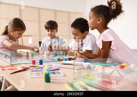 Bambini piccoli dipingendo sull'acqua durante la lezione di master a Ebru in officina Foto Stock