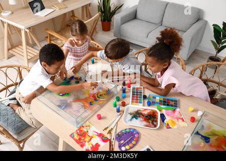 Bambini piccoli dipingendo sull'acqua durante la lezione di master a Ebru in officina Foto Stock