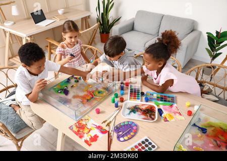 Bambini piccoli dipingendo sull'acqua durante la lezione di master a Ebru in officina Foto Stock