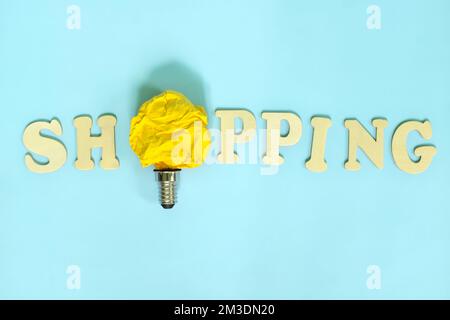 Shopping suggerimenti e idee concetto. Lampadina luminosa in carta stropicciata giallo brillante. Foto Stock