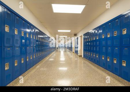 Tipico corridoio della scuola vuoto degli Stati Uniti, senza descrizione, con armadietti in metallo blu lungo un corridoio. Foto Stock