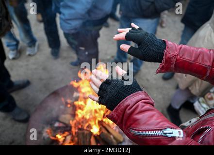 Berlino, Germania. 14th Dec, 2022. I senzatetto riscaldano le mani durante una festa di Natale al diaconale "Tagesstätte Sozialprojekt" per i senzatetto di Helmholtzplatz. Credit: Jens Kalaene/dpa/Alamy Live News Foto Stock