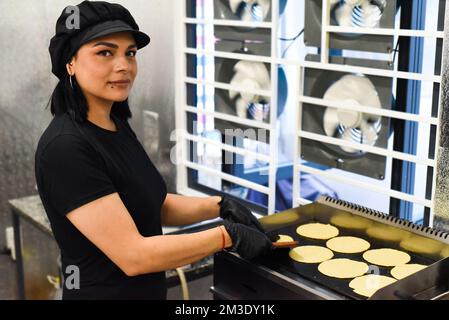 Donna messicana che fa tacos in una cucina di un caffè messicano Foto Stock