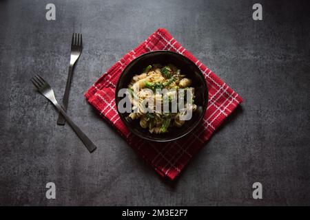 Primo piano della popolare pasta con ingredienti alimentari servita in una ciotola. Messa a fuoco selettiva. Foto Stock
