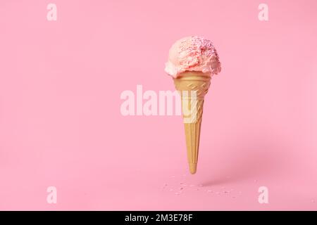 estate divertente concetto creativo di volare wafer cono sessole di gelato decorate con spolverate su sfondo rosa Foto Stock