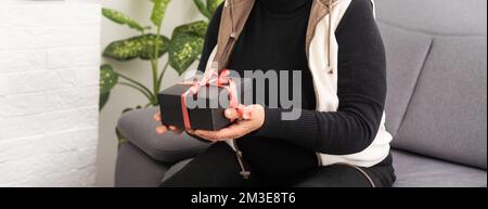 donna la confezione regalo. Sposi Natale e buone feste Foto Stock