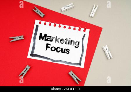 Concetto di business e finanza. Vestiti e un foglio di taccuino con l'iscrizione - Marketing Focus Foto Stock