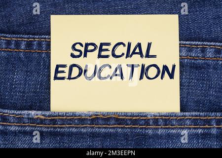 Economia e concetto di istruzione. C'è una carta che sporge da una tasca di jeans con l'iscrizione - Educazione Speciale Foto Stock