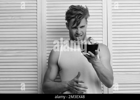 L'uomo con l'espressione disgustata del volto guarda la ciotola Foto Stock