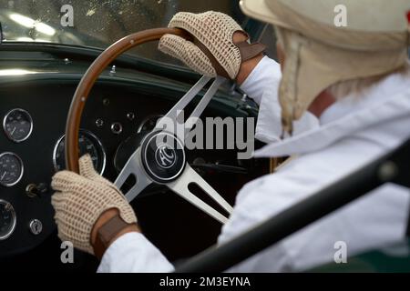 Mani sul volante di un'auto driving.mani di un uomo in classico inglese guanti da guida in pelle in auto classica . Foto Stock