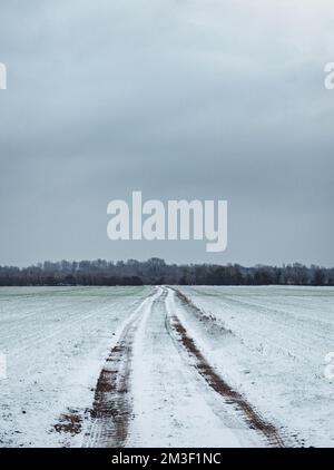 Il veicolo segue un campo ghiacciato nel paesaggio rurale dell'Oxfordshire. Foto Stock