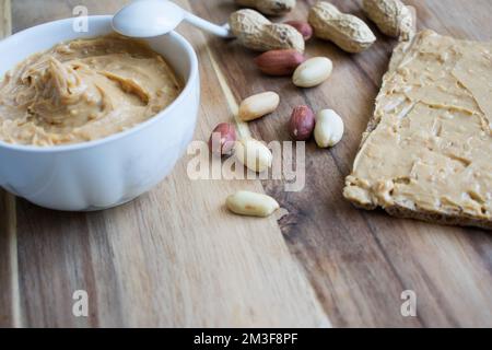 Burro di arachidi in ciotola, cibo sano e biologico. Foto Stock