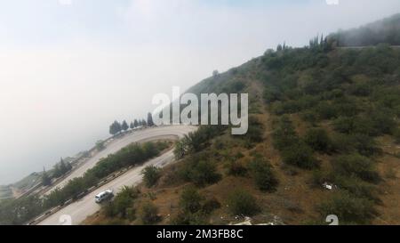 Una lunga strada sulla montagna. Shot.A lungo tracciato per automobili è situato su un pendio alto e nebbia spessa è visibile sul paesaggio. Footag 4K di alta qualità Foto Stock