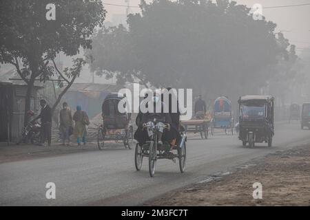 Dhaka, Bangladesh. 14th Dec, 2022. Un autista di risciò porta i passeggeri a destinazione in una mattina invernale nebbiosa a Dhaka. Credit: SOPA Images Limited/Alamy Live News Foto Stock