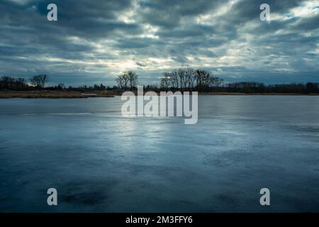 Vista serale di un lago ghiacciato e cielo nuvoloso, Stankow est Polonia Foto Stock