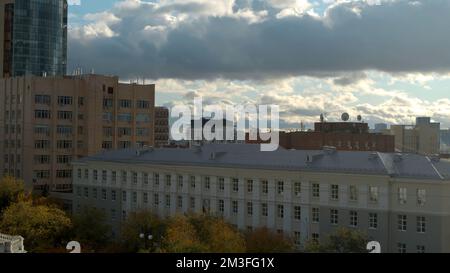 Serbia, Belgrado - 7 maggio 2022: Volare sopra le case e gli edifici su uno sfondo cielo nuvoloso blu. Riprese in stock. Edifici residenziali nella città ce Foto Stock