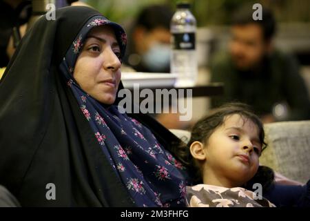 Teheran, Teheran, Iran. 14th Dec, 2022. Una donna velata iraniana guarda una trasmissione dal vivo della partita semifinale di calcio della Coppa del mondo del Qatar 2022 tra Marocco e Francia al caffè Nakhlestan nel centro di Teheran, Iran, il 14 dicembre 2022. Tifosi provenienti da Iran, Libano, Yemen, Siria e Palestina si riuniscono al caffè Nakhlestan, gestito e di proprietà dell'Owj, Islamic Revolutionary Guard Corps (IRGS) Arts and Media Organization, per sostenere la nazionale marocchina. Dopo la vittoria contro il Portogallo in Qatar il 10th dicembre, i marocchini portarono bandiere palestinesi per dimostrare il loro sostegno al Palestina Foto Stock