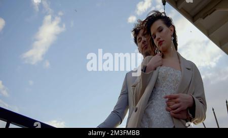 Ritratto degli sposi novelli nella strada della città. Azione. Bella sposa caucasica, sposarsi abbracciando il loro giorno di nozze Foto Stock