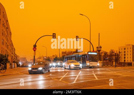 Centro città coperto da una tempesta di polvere d'arancia si è formata in Africa, calima, sabbia aerea dal deserto del Sahara. Malaga, Costa del Sol, Spagna. Foto Stock