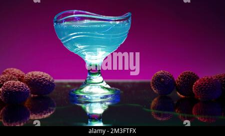 Cocktail blu su un banco bar con bacche di lychee. Clip di scorta. Concetto di vita notturna, discoteca bar e divertimento Foto Stock