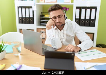 Giovane uomo ispanico agente call center che lavora stanco dormire in ufficio Foto Stock