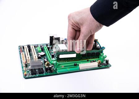 Installazione di una nuova memoria DDR RAM per un socket del processore del personal computer in un servizio. Aggiornamento della riparazione. Concetto di aggiornamento o riparazione del PC. Isolato Foto Stock
