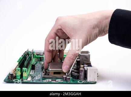 Ingegnere repairman tenendo le mani in guanti neri chip processore, CPU da inserire nella presa della scheda madre del computer. Il concetto di tecnologia Foto Stock