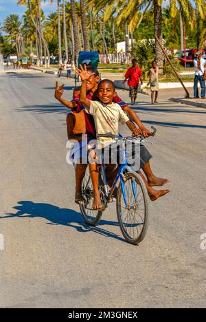 Happy boys in bicicletta attraverso le strade di Toliara, Madagascar Foto Stock