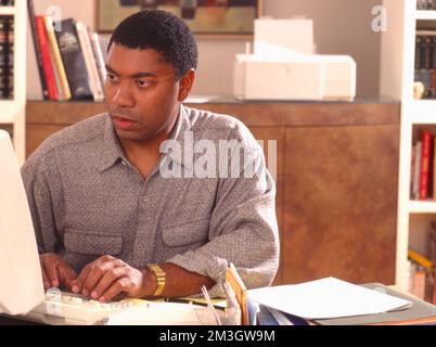 Uomo afroamericano che lavora su un computer Foto Stock