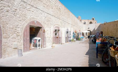 Strada con bazar turco sotto il caldo sole splendente. Azione. Piccoli negozi vuoti e una strada stretta su sfondo blu cielo Foto Stock