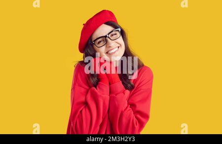 Ritratto di felice bella giovane donna rosso berretto autunno, guanti e occhiali Foto Stock