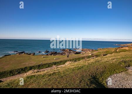 Newquay, Cornwall, 15th dicembre 2022, la gente che gode il sole glorioso in un giorno sole bello ma molto freddo in Fistral Beach, Cornwall. La spiaggia è famosa come la gente viaggia da tutto il paese per cavalcare le onde famose con le condizioni di surfing.Credit: Keith Larby/Alamy Live News Foto Stock