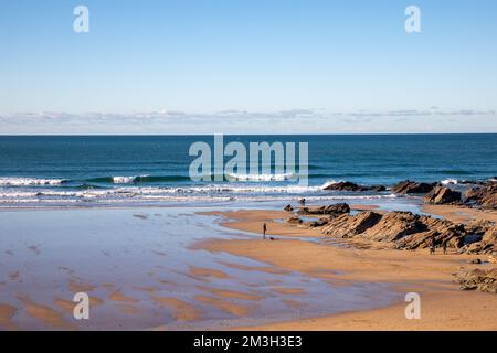 Newquay, Cornwall, 15th dicembre 2022, la gente che gode il sole glorioso in un giorno sole bello ma molto freddo in Fistral Beach, Cornwall. La spiaggia è famosa come la gente viaggia da tutto il paese per cavalcare le onde famose con le condizioni di surfing.Credit: Keith Larby/Alamy Live News Foto Stock