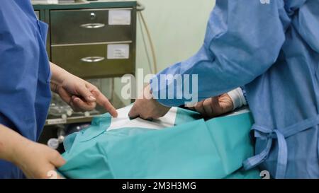 Un team di chirurghi in sala operatoria durante la procedura. Creativo. Tecnologie mediche, concetto di malattia Foto Stock