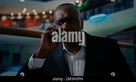 Uomo di etnia afro-americana adulto di mezza età imprenditore maturo triste sconvolto sottolineato confuso emotivo uomo d'affari uomo parlando telefono cellulare sentire male Foto Stock