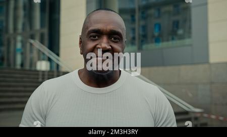 Etnia anziano di mezza età adulto maturo 50s amichevole uomo afroamericano consulente commerciale sorridente faccia maschile all'aperto in città guardando la macchina fotografica Foto Stock