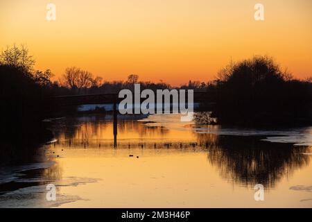 Dorney, Buckinghamshire, Regno Unito. 15th dicembre 2022. Dopo un'altra giornata di temperature inferiori allo zero il sole tramonta sul fiume Jubilee di Dorney, che ora ha una notevole quantità di ghiaccio superficiale. Il fiume Jubilee è uno schema di riduzione delle alluvioni che protegge Windsor, Eton e Maidenhead in caso di alluvioni. È anche un paradiso per gli uccelli migratori. Credit: Maureen McLean/Alamy Live News Foto Stock