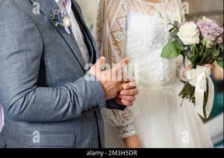 Le spose mettono sugli anelli di nozze sulle loro barrette, nozze nella chiesa. Foto Stock