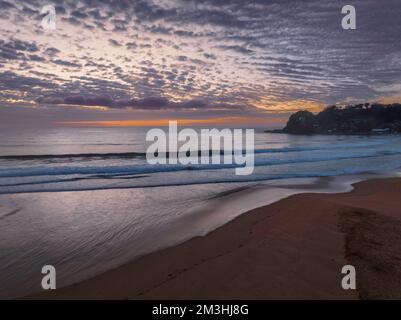 Alba aerea sul mare con nuvole rmedium che si estendono attraverso il cielo a Avoca Beach sulla costa centrale, NSW, Australia. Foto Stock